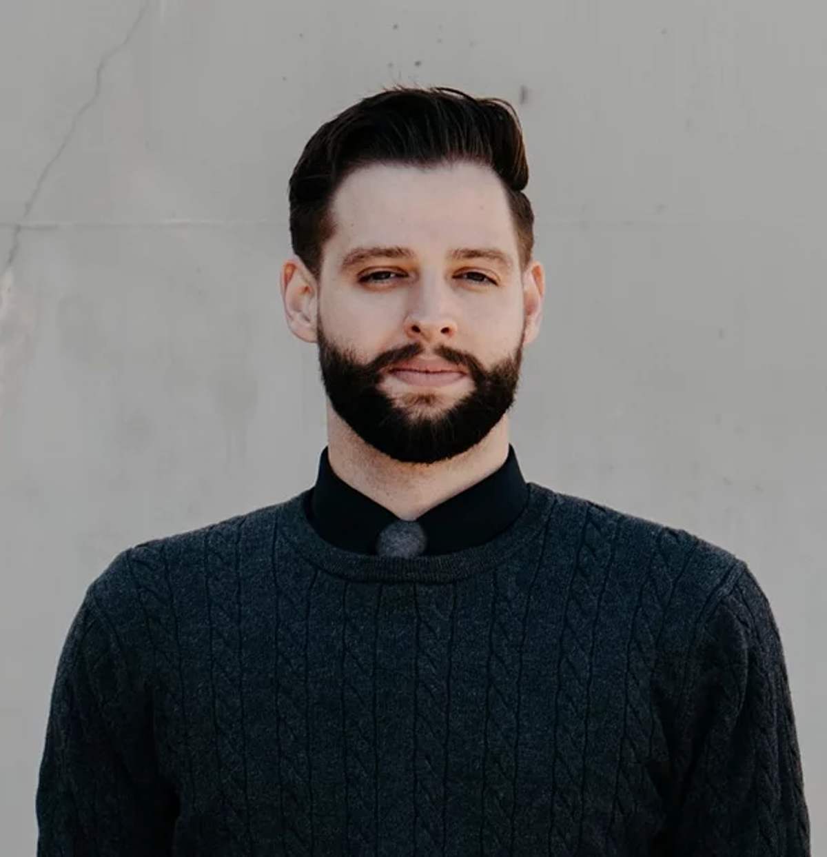 Portrait of a bearded young pastor in a dark sweater