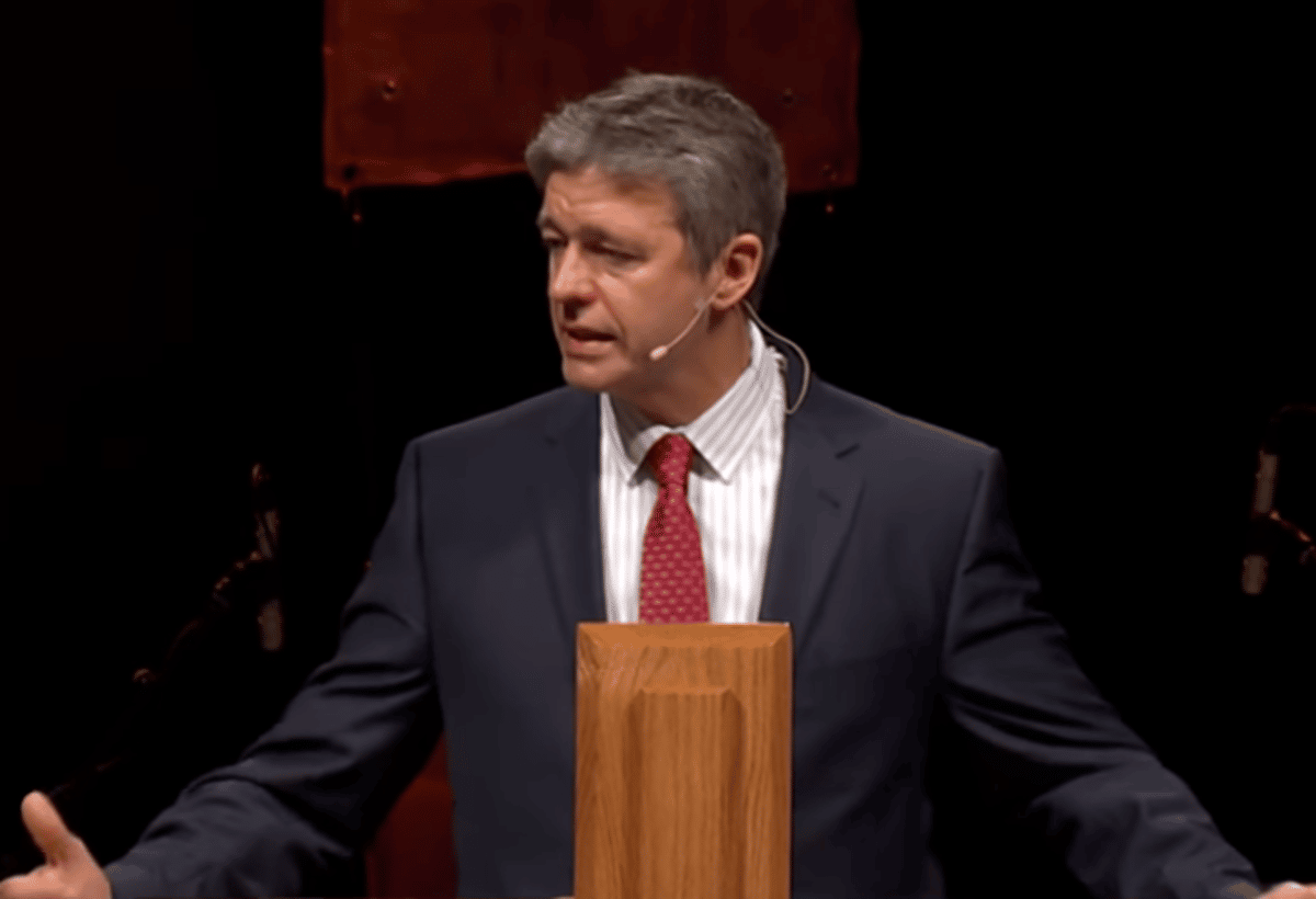 Paul Washer preaching from a wooden pulpit